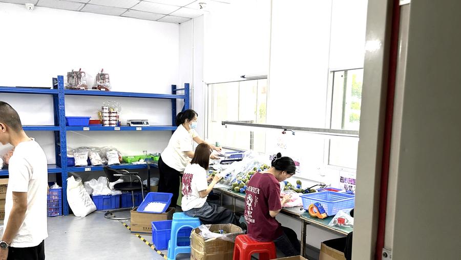 Staff assembling and bagging components at packing benches