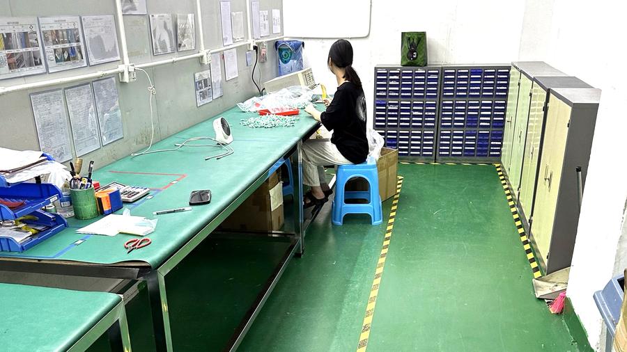 Incoming inspection bench with specification sheets posted on the wall